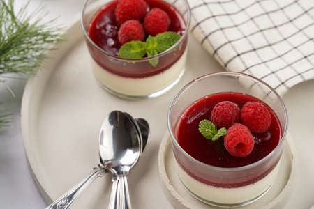 Italian dairy dessert panna cotta with raspberry jam and fresh raspberries on concrete trayの写真素材