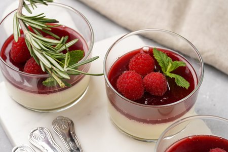 Italian dairy dessert panna cotta with raspberry jam, fresh raspberries and mint on marble boardの写真素材