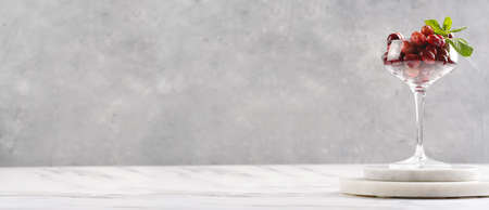 Wide champagne glass filled with fresh raw cranberries on a round marble tray, bannerの写真素材