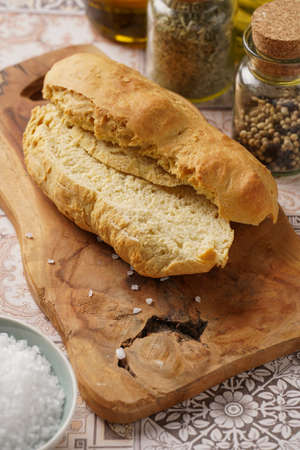 A loaf of homemade wheat bread on a wooden board on oriental surfaceの写真素材