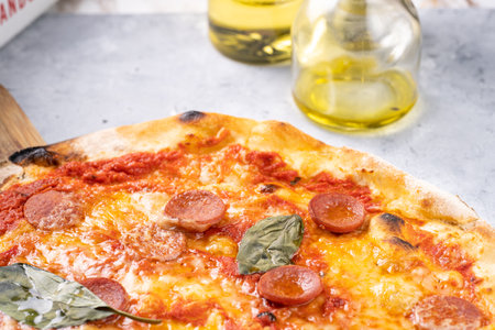 Freshly baked traditional mediterranean pizza with tomato sauce marinara, mozzarella cheese, pork sausage salsiccia and basilの写真素材
