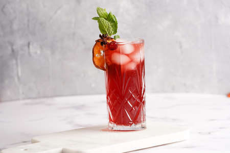 Traditional christmas beverage mulled wine with red cherry juice, orange tangerines, cinnamon...