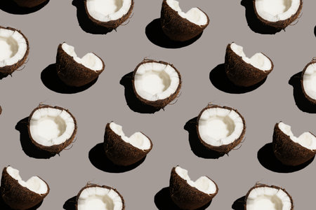 Hard light sunny seamless pattern of a cracked coconut on a gray background