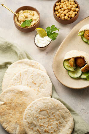Traditional oriental chickpea deep fried falafel in flatbread pita, tzatziki yoghurt sauce, hummus,...