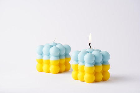 Two patriotic bubble candles - half blue, half yellow on white seamless surfaceの写真素材