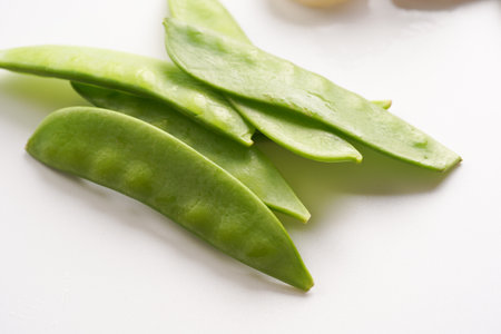 Ingredients for a spicy thai coconut soup or curry: snow pea on white background