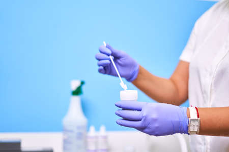 Doctors hands in purple gloves collecting tests for testing. High quality photo