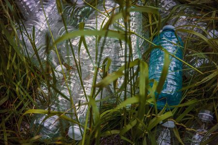 Plastic bottles in the green grass. Problem in the natural environment, pollution of nature is not decomposing plastic. Protection of Nature.の写真素材