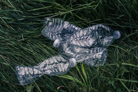 Ecology concept. Plastic bottles in the green grass. The problem of ecology, environmental pollution. Protection of Nature.の写真素材
