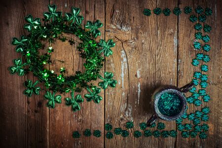 St. Patricks Day composition. Shamrock wreath, shamrocks and silver pot on an old rustic wood background. St.Patrick's day holiday symbol. Top view, copy space.の写真素材
