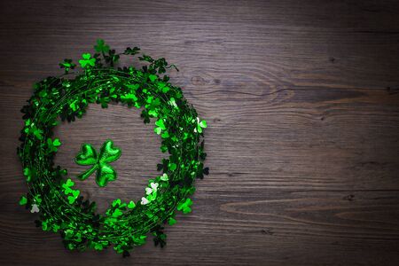St. Patricks Day composition. Shamrock wreath, shamrocks on an old rustic wood background. St.Patrick's day holiday symbol. Top view, copy space.の写真素材