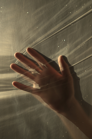the girl's hand through the transparent fabricの写真素材