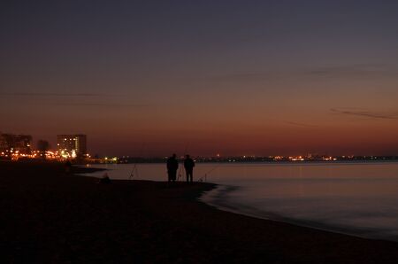 Two fishermen after sunsetの写真素材