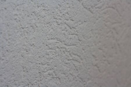 Abstract light beige grainy background with the texture of coarse-grained new decorative plaster. Construction and repair.の写真素材