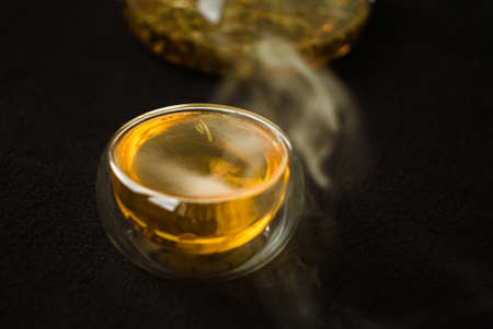 greentea is poured Into a glass mug, splashes and bubbles