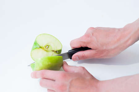 Female hands cutting apple with knife.の写真素材