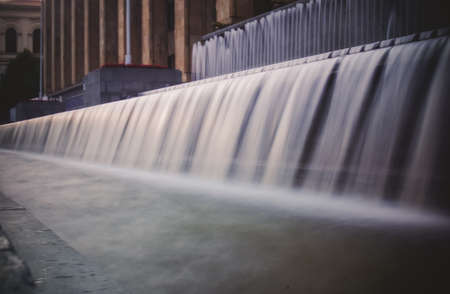 Long exposure city fountain at dusk.