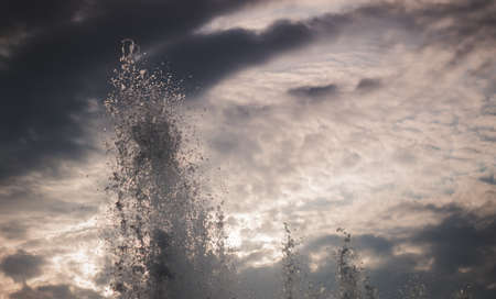 Splash of a fountain against the sky on a windy dayの写真素材