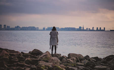 a girl looks at the landscape on the Bay.City in the distanceの写真素材