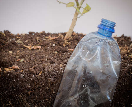 Plastic bottle in the soil.Pollution of the planet with plastic waste.の写真素材