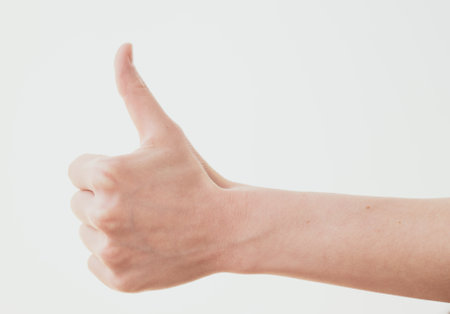 Female hand with thumb up gesture on white background