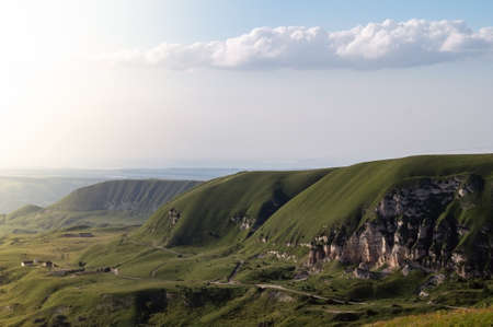 Landscape with green hills, mountains and blue sky. Beautiful natural panorama with copy space.