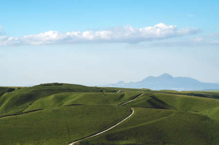 Landscape with green hills, mountains and blue sky. Beautiful natural panorama with copy space.の写真素材