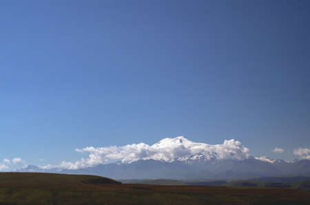 Beautiful plain landscape with snowy mountains in the distance. Copy space.