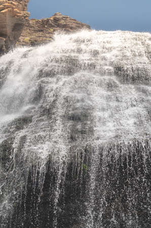 A beautiful waterfall in the mountains. Fresh water flows down from the glacier. Close up