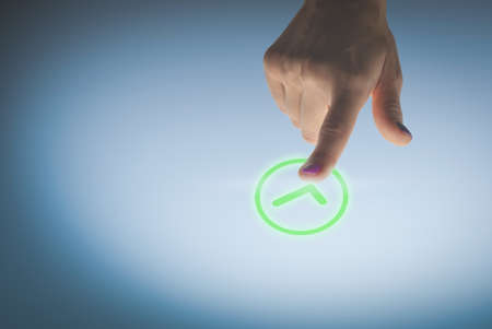 Woman hand pressing a green validation button, image concept of approval.