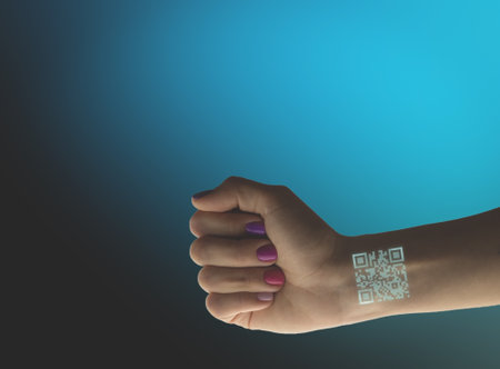 Woman shows QR code. Covid vaccination certificate on female hand isolated on blue background.の写真素材