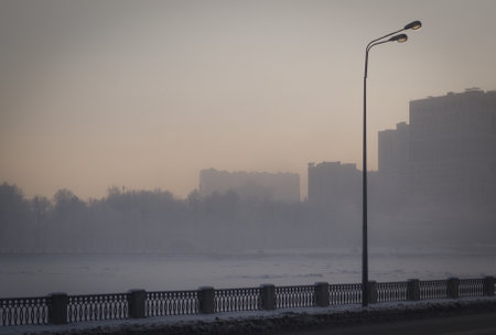 Street lamp at sunset on a winter evening. Nayuerezhnaya river in St. Petersburg.の写真素材