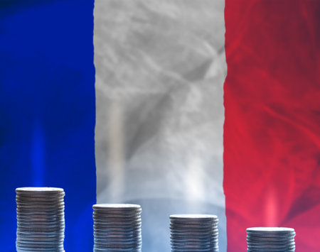 Stacks of gold coins in front of flag of France symbolizing crisis in economy of the country. Regression of the economy conceptの写真素材