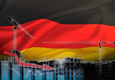 Construction cranes on the background of the flag of Germany. The concept of a crisis in construction.の写真素材