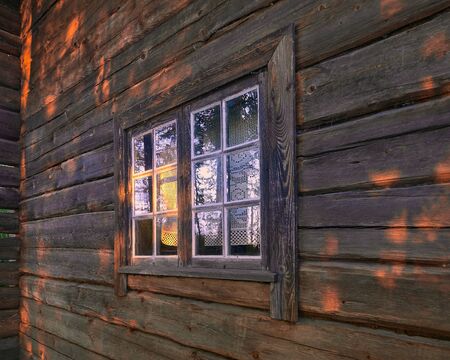 Window of an old country house illuminated by the rays of the evening sun.の写真素材