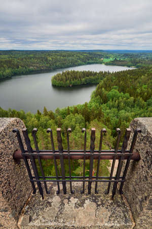 A vertical panorama from the top of the Aulanko tower near the Finnish town of Hamenlinna: the lattice of the tower, forests, lake, clouds.の写真素材