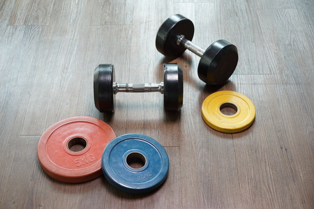 Two dumbbells on the wood floor in gym, sport equipmentの写真素材