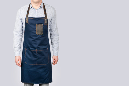 A man in a blue Chef apron on a gray background.の写真素材