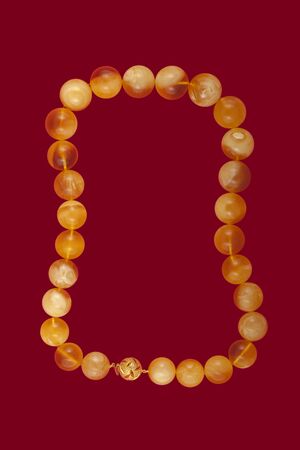 Baltic amber closeup on red background.の写真素材