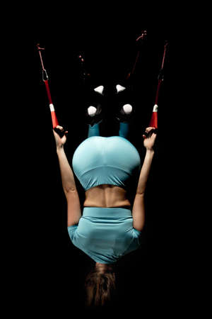 Alfagravity training, a new sport. Young athletic woman in sports clothing training legs with...