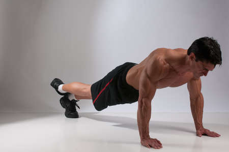 The handsome man does an exercise routine for the photo.