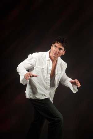 Young man in white shirt on a dark background. Studio shot.