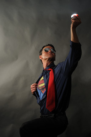 Portrait of a man dressed in superhero costume on a dark backgroundの写真素材