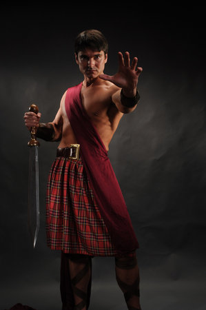 Kung fu master with sword and scottish tartan skirtの写真素材