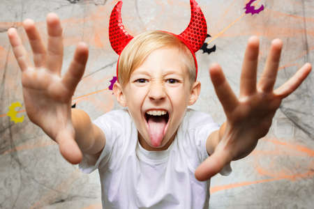 baby shows funny faces for the camera on Halloweenの写真素材