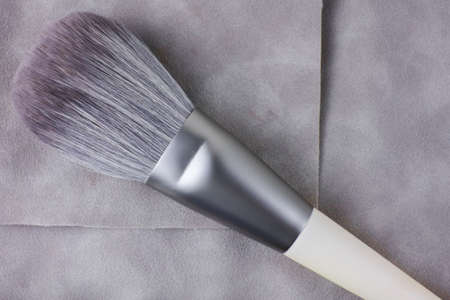 the makeup brush is on a suede case