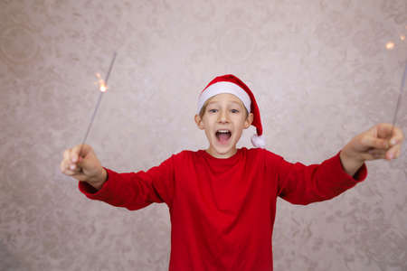happy boy in a Santa Claus hat with sparklersの写真素材