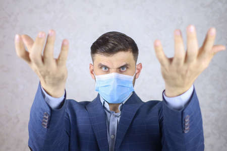 a man in a medical mask shows hand gesturesの写真素材