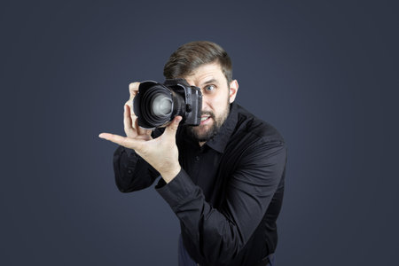 a man in a black shirt and on a black background shows the palms of his hands gestures