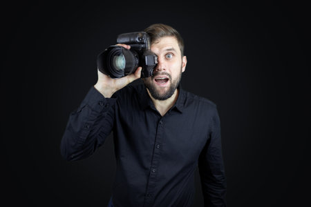 a man in a black shirt and on a black background shows the palms of his hands gestures